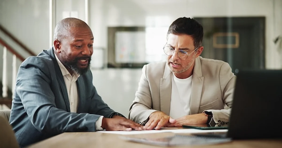 Empresário e contador analisando documentos de abertura de empresa