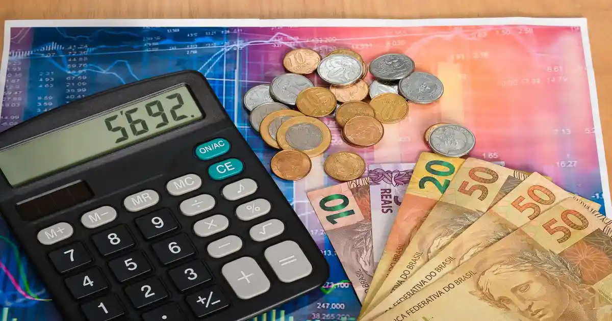 Calculadora e notas de reais representando custos para abrir empresa em Santa Catarina